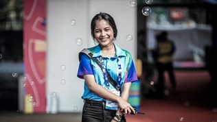 Illustrtion photo: Young woman standing with accreditation card and a walkie-talkie.